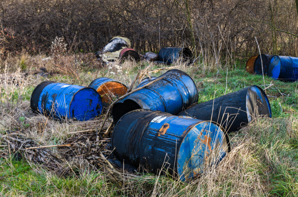 Barrels of toxic waste in nature, pollution of the environment.