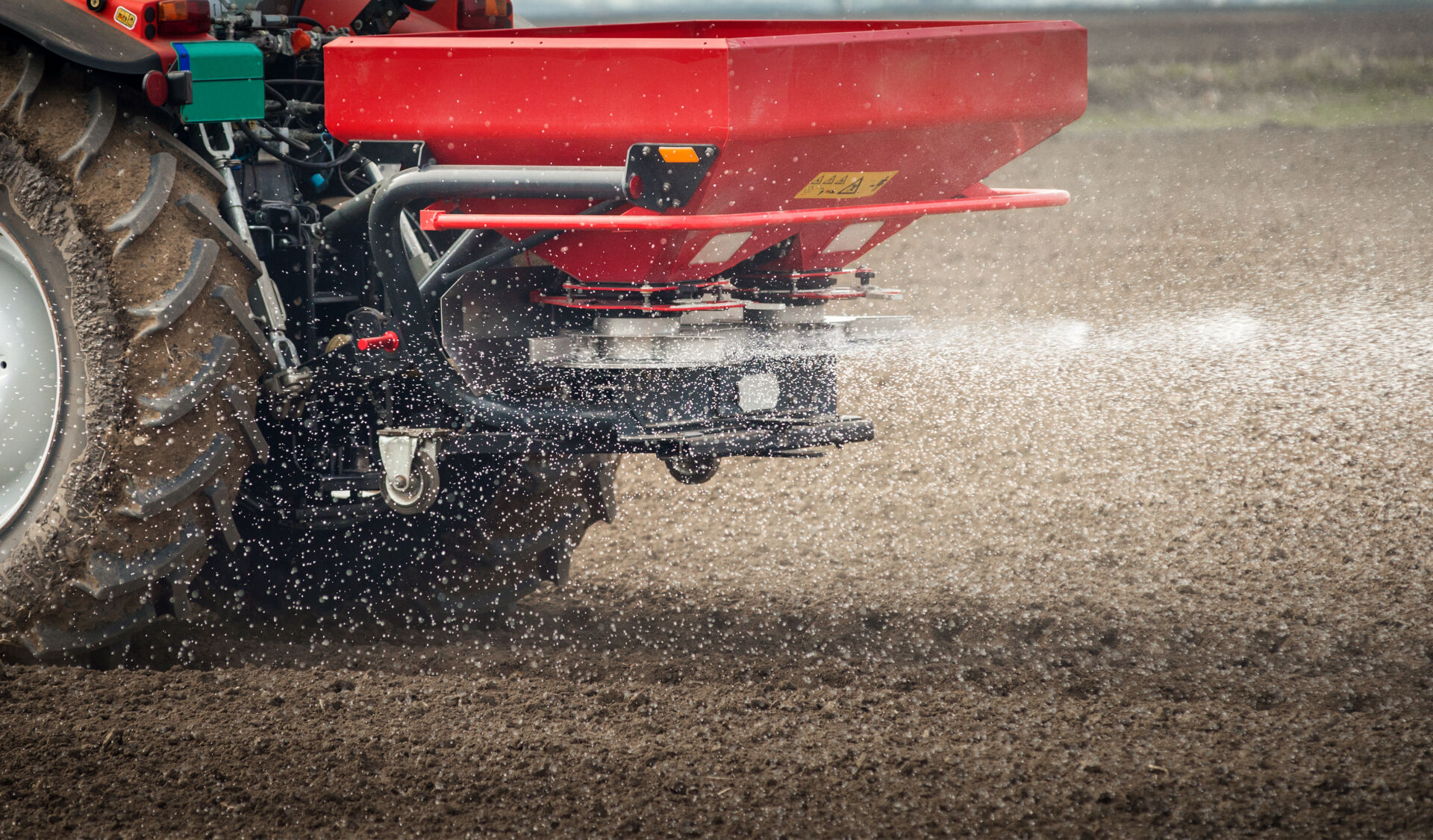 Tractor and fertilizer spreader in field