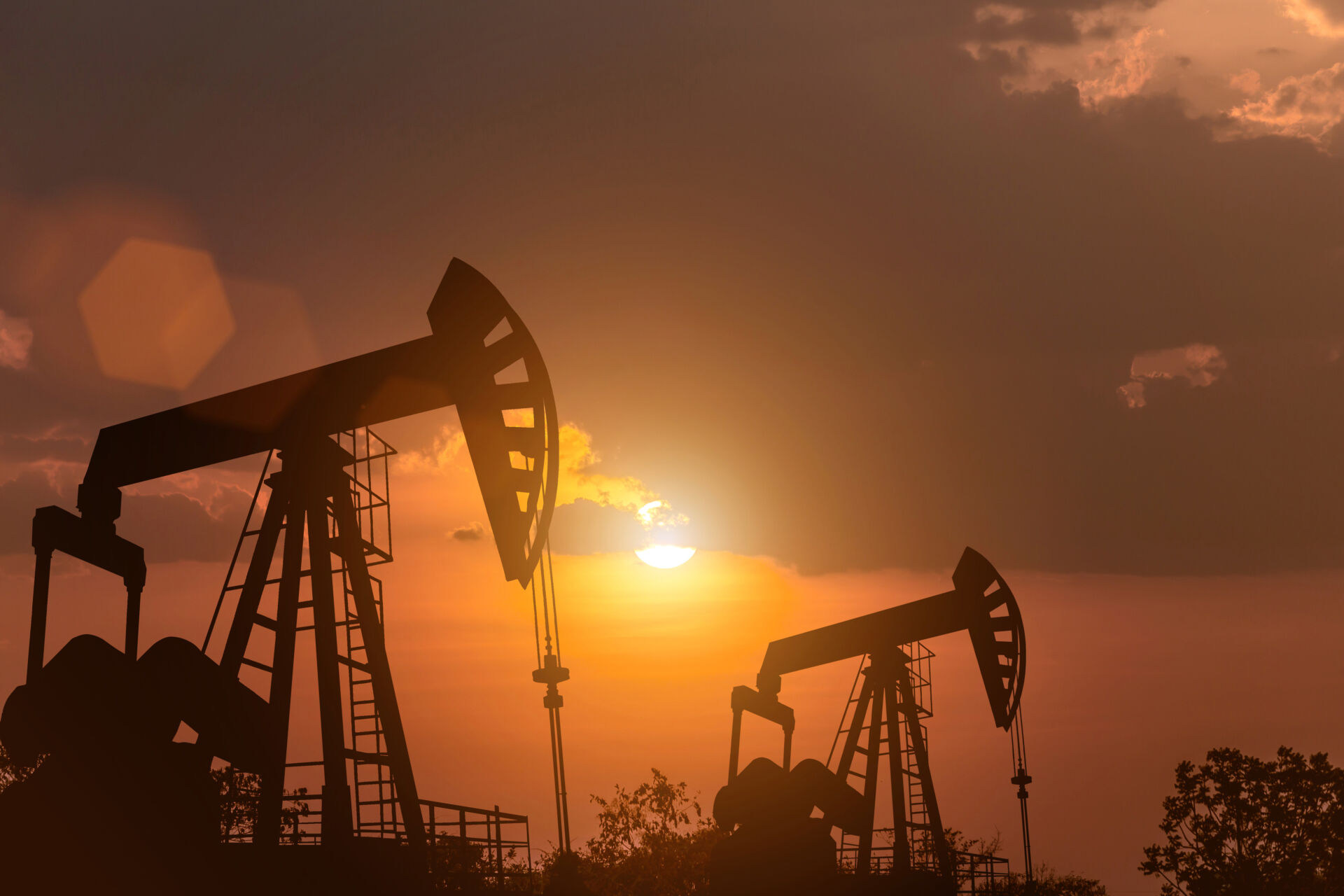 Silhouette of the pump oil rig energy industrial machine for petroleum in the Beautiful sunset background